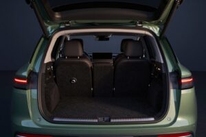 The open boot of the moss green SUV, with a flat carpeted floor and the rear seats beyond