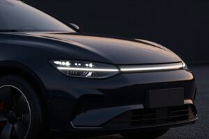 Slim headlight with a row of glowing light elements on the black executive saloon