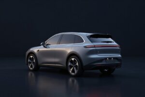 Graphite grey electric SUV seen from behind, with slim tail lights, in a dark showroom