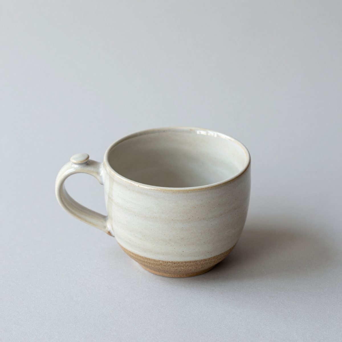 The speckled stoneware mug seen from slightly above, showing the glaze inside and the thumb rest