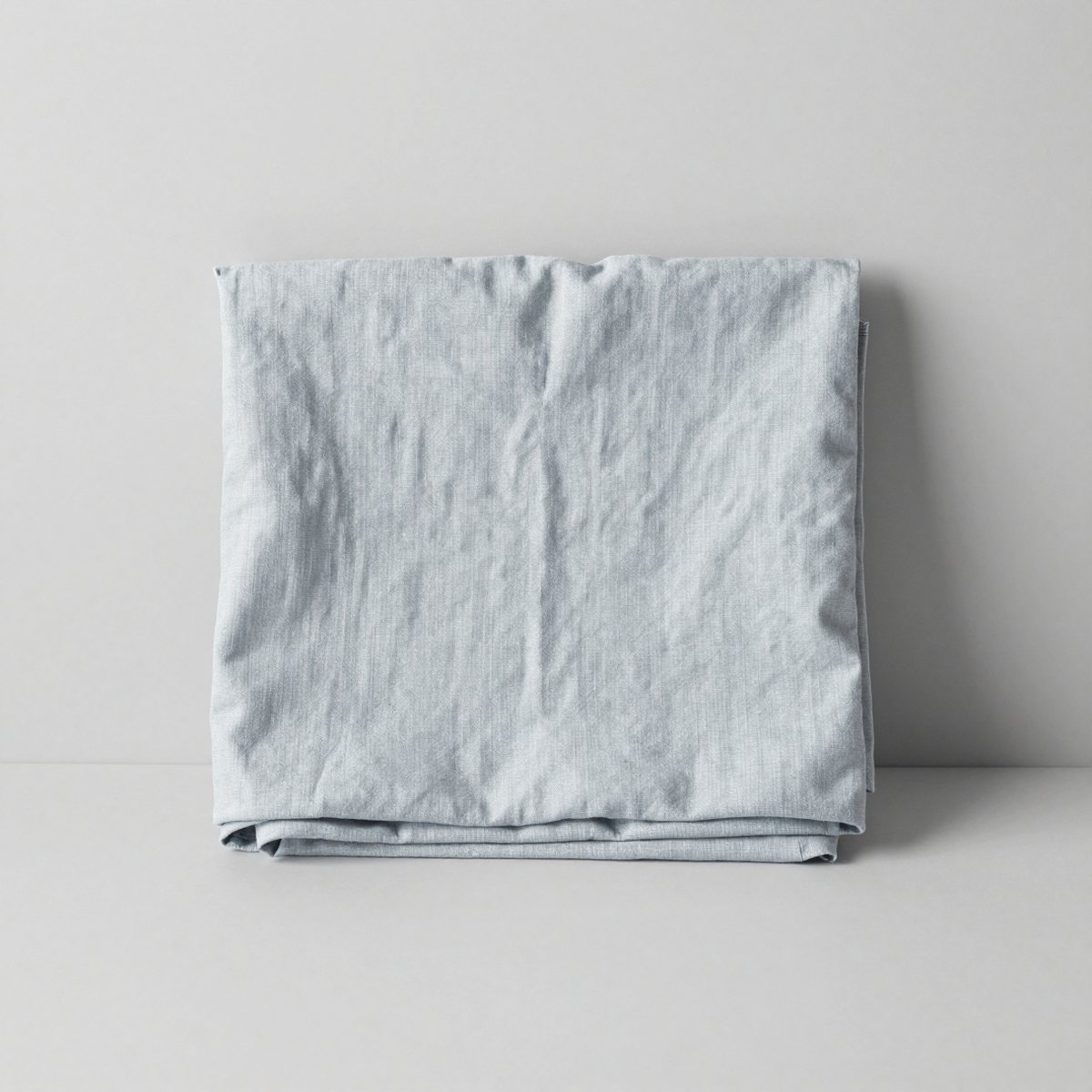 The linen tablecloth folded and standing upright, showing its soft creases