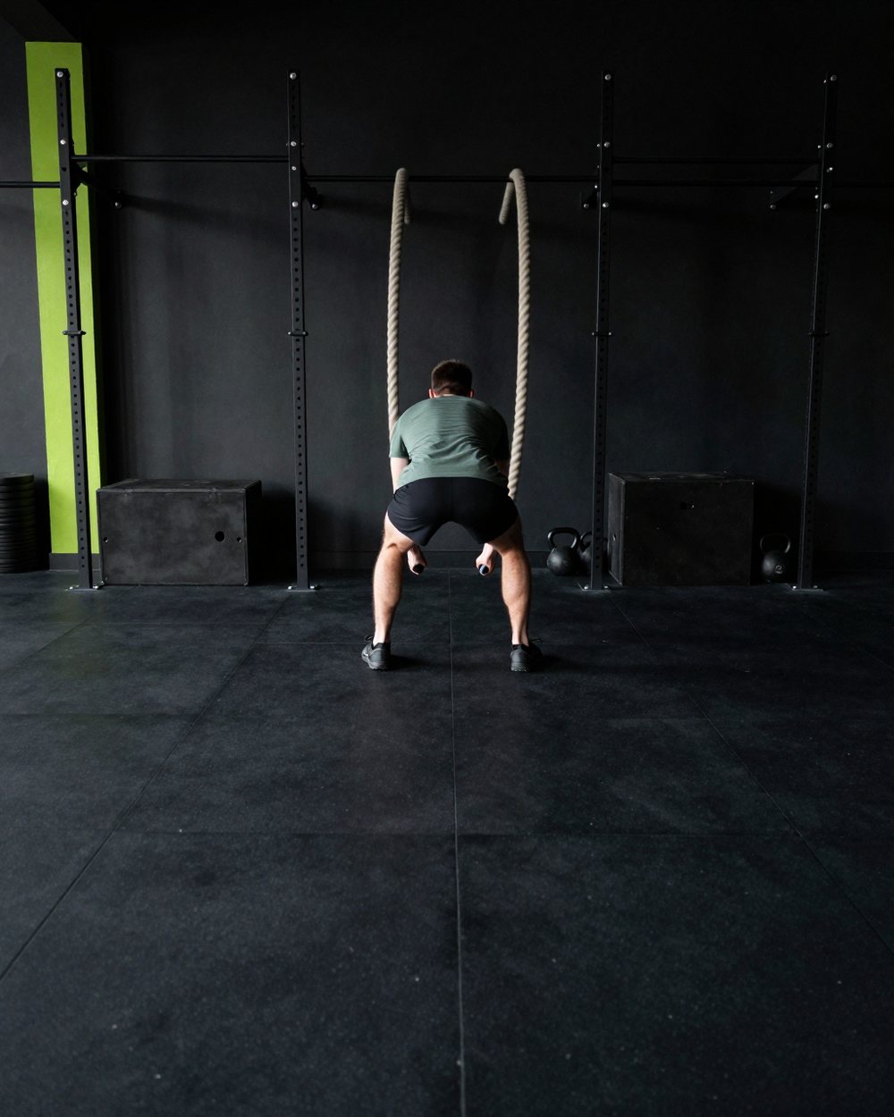 An athlete swinging two heavy battle ropes