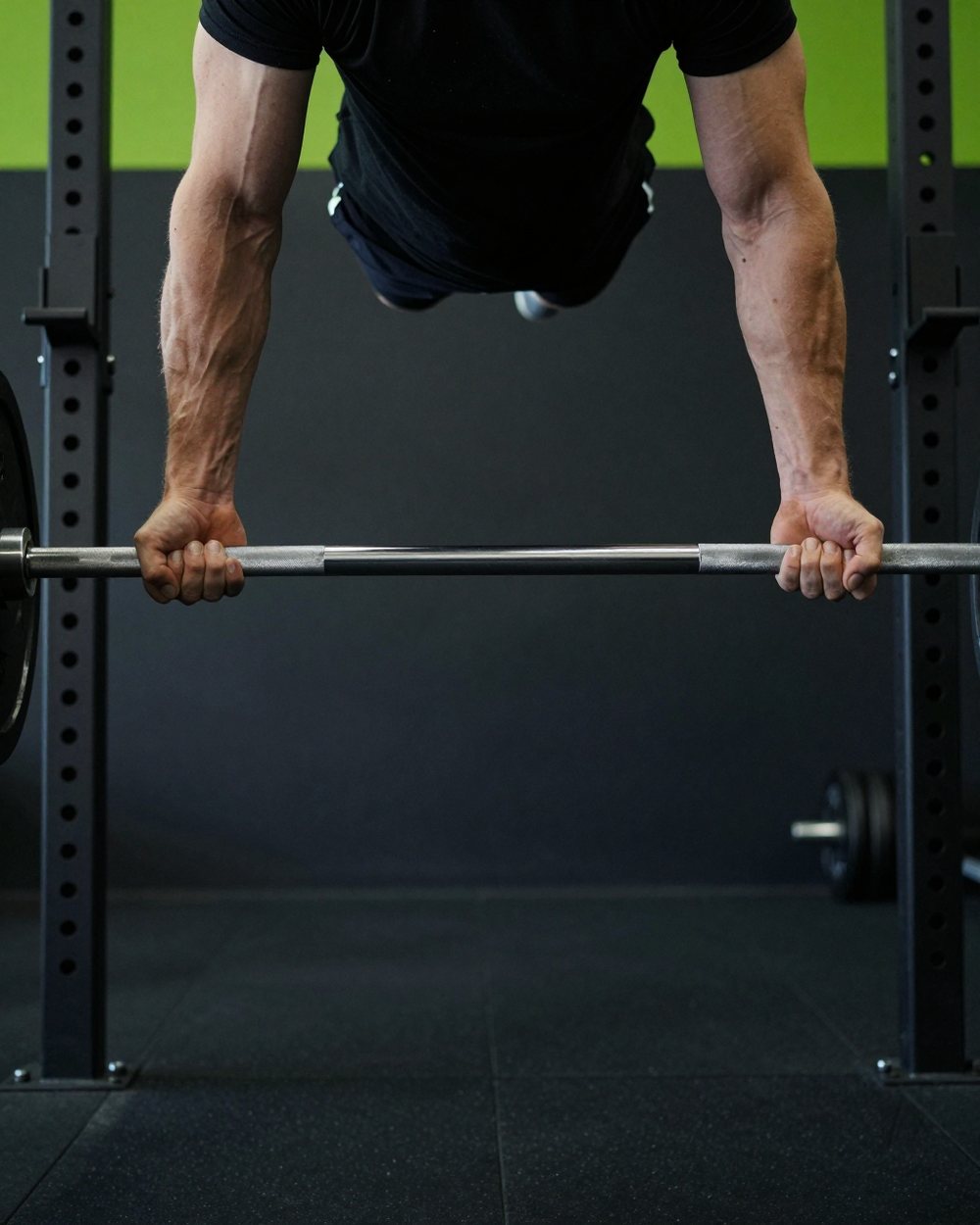 Chalked hands gripping a loaded barbell